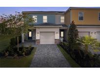 Charming two-story townhome with a well-manicured front yard and a paved driveway leading to an attached garage at 772 Driving Range Ct, Kissimmee, FL 34747