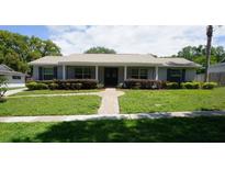 Charming single-story home featuring a manicured front lawn and inviting entrance at 8613 Edge O Woods Ct, Orlando, FL 32819