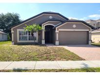 Charming single-story home with a two-car garage and well-maintained landscaping, creating excellent curb appeal at 928 Chanler Dr, Haines City, FL 33844
