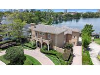 Stunning Mediterranean-style home featuring a tile roof, arched entry, and lush landscaping with a brick-paved driveway at 1010 Terrace Blvd, Orlando, FL 32803