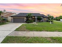 Charming single-story home with a well-manicured lawn and inviting curb appeal under a colorful sky at 11900 Frieth Dr, Orlando, FL 32837
