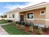 Charming single-story home with a terracotta roof, manicured lawn, and inviting front porch at 1800 Coriander Dr, Kissimmee, FL 34759