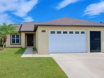 Charming single-story home features a well-maintained lawn, inviting entrance, and a convenient two-car garage at 3260 Pinto Dr, Kissimmee, FL 34746