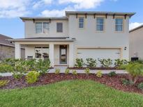 Charming two-story home with landscaped yard, inviting front porch, and a two-car garage at 3326 Wynwood Forest, Ocoee, FL 34761