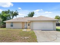 Charming single-story home with a well-manicured lawn, attached two-car garage, and neutral-colored exterior at 831 Lindley Blvd, Deland, FL 32724