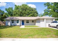 Charming single-story home with a well-maintained lawn, complemented by a bright blue front door at 110 N Alderwood St, Winter Springs, FL 32708