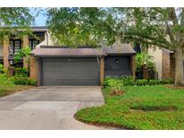 Charming home featuring a two-car garage with lush landscaping and mature trees enhancing its curb appeal at 1122 Washington Ave # 7, Winter Park, FL 32789