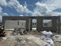 The shell of the house is under construction with a clear blue sky and clouds in the background at 1153 Basalt Ln, Sanford, FL 32771