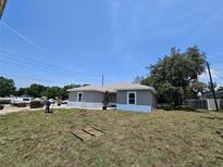 Landscaped backyard of newly constructed single-story home showing gray exterior paint, and freshly laid sod at 141 W G H Washington St, Apopka, FL 32703