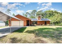 Charming single-story home with a cozy appeal, featuring a lush front lawn and attached garage with covered parking at 175 Cliff St, Deland, FL 32720