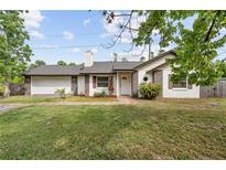 Charming single-Gathering home featuring a brick and white exterior, well-maintained lawn, and attached garage at 2040 E Triangle Dr, Longwood, FL 32779