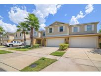 Charming townhomes with well-manicured lawns and attached garages under a sunny sky at 3530 Rodrick Cir, Orlando, FL 32824