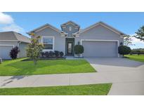 Charming single-story home features a well-manicured lawn and a two-car garage at 567 Pinecrest Loop, Davenport, FL 33837