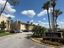 Welcoming community entrance featuring lush landscaping, palm trees, and access to Sandy Cove Condominiums at 592 Orange Dr # 142, Altamonte Springs, FL 32701