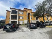 Beautiful apartment building with a balcony and parking spaces on a sunny day at 6169 Metrowest Blvd # 102, Orlando, FL 32835