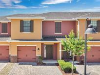 Charming townhome featuring a brick driveway, a one car garage, and inviting curb appeal with landscaping at 617 Joyful Blossom Pl, Longwood, FL 32750