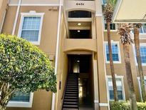 Attractive condo building with stairwell, large windows, and nearby mature trees and landscaping at 6451 Old Park Ln # 102, Orlando, FL 32835