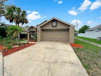 Charming home featuring a two-car garage, well-maintained lawn, and vibrant landscaping at 721 Rock Creek Loop, Longwood, FL 32750