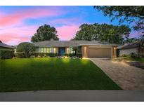 Charming single-story home with lush landscaping, brick accents, and a paver driveway at 7549 Lake Marsha Dr, Orlando, FL 32819