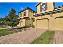 Two-story home with a beautiful brick driveway and well-maintained landscaping on a sunny day at 8187 Roseville Rd, Davenport, FL 33896