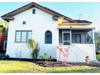Charming home with a stucco exterior, terra cotta roof, a screened porch, and landscaped front yard at 900 Carlton Ave, Lake Wales, FL 33853