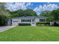 Charming single-story home features a lush green lawn, well-manicured hedges, and an attached one car garage at 915 Oregon St, Orlando, FL 32803