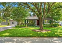 Charming single-story home featuring a well-maintained lawn and a mature shade tree in a quiet neighborhood at 927 Boardman St, Orlando, FL 32804