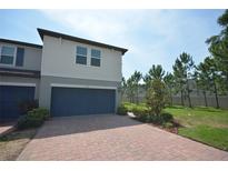 Charming two-story home with a two-car garage and neatly manicured landscaping, with a brick driveway at 971 Desert Candle Dr, Ocoee, FL 34761