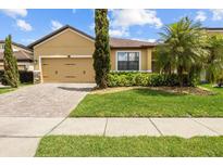 Inviting single-story home with a well-manicured lawn and paver driveway, showcasing curb appeal at 10111 Tierra Bella Dr, Orlando, FL 32825