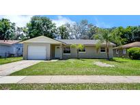 Charming single-story home with a well-manicured front yard and a driveway leading to a single-car garage at 14 Cyclops Dr, Apopka, FL 32703