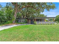 Charming single-story home boasts a manicured lawn, stylish driveway and welcoming covered entrance at 1401 Canberra Ave, Orlando, FL 32806