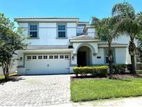 Charming two-story home featuring a two-car garage, tiled roof, and well-manicured landscaping at 1513 Maidstone Ct, Davenport, FL 33896