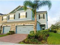 Charming townhome with a two-car garage and lush landscaping at 15708 Orange Harvest Loop, Winter Garden, FL 34787