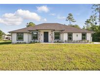 Charming single-story home featuring a manicured lawn, neutral stucco, stone accents, and a welcoming dark front door at 19073 Sabal St, Orlando, FL 32833