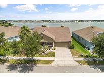 Aerial view of single-Gathering home with landscaped front yard, lake view and long driveway at 259 Blue Cypress Dr, Groveland, FL 34736