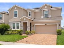 Beautiful two-story home featuring a brick paver driveway, two-car garage, and stone accents at 2940 Nottel Dr, St Cloud, FL 34772