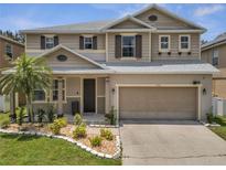 Charming two-story home with a well-manicured lawn, complemented by a two-car garage and neutral color scheme at 325 Aldridge Ln, Davenport, FL 33897