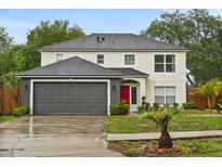 Charming two-story home featuring a well-maintained lawn and inviting red front door at 3591 Sandlor Dr, Deltona, FL 32738