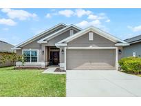 Charming single-story home with a well-manicured lawn, a two-car garage, and a welcoming entryway at 503 Meadow Pointe Dr, Haines City, FL 33844