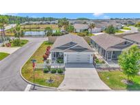 Charming single-story home boasts a manicured lawn, picket fence, and view of the pond in a peaceful community at 6223 Atkinson Ln, The Villages, FL 32163