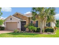 Charming single-story home featuring a stone facade, well-manicured lawn, and a mature palm tree at 634 Via Corso Ct, Kissimmee, FL 34759