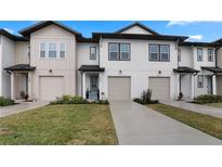 Charming townhouse featuring a modern design with a one-car garage and well-maintained lawn at 733 Longboat Dr, Davenport, FL 33896
