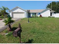 Charming single Gathering home featuring a well-manicured lawn and attached garage at 1100 Peak Cir, Deltona, FL 32738