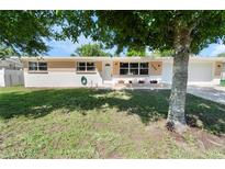 Charming single-story home featuring a well-maintained lawn, a brick accent, and mature shade trees at 1340 Continental Dr, Daytona Beach, FL 32117