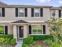 Charming townhome featuring a well-manicured lawn and black shutters that accentuate the gray facade at 1555 Dawnview Way, Kissimmee, FL 34744