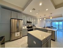 Modern kitchen features stainless steel appliances, gray cabinetry, and a center island with quartz countertops at 16300 County Road 455 # 703, Montverde, FL 34756
