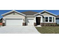 Charming single-story home featuring a three-car garage, stone accents, and well-manicured landscaping at 2117 Greenwood Oak Dr, Ocoee, FL 34761
