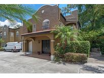 Charming two-story home featuring a covered entryway, red tile roof, and lush tropical landscaping in a well-maintained community at 2238 Hawick Ln # 2238, Winter Park, FL 32792