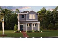 Charming two-story home with gray siding and a cozy front porch surrounded by lush landscaping at 2454 Peace Of Mind Ave, Kissimmee, FL 34744