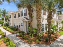 Inviting townhome with lush landscaping and mature palm trees providing shade and curb appeal at 2952 Lucayan Harbour Cir # 105, Kissimmee, FL 34746